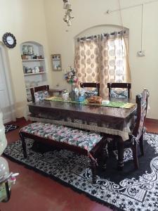 - une salle à manger avec une table et deux chaises dans l'établissement Zeus Bungalow, à Kotagiri
