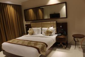 Postel nebo postele na pokoji v ubytování Mango Hotels Vijayawada + 8 fotografií