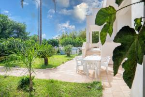 a patio with a white table and chairs at CASA DE ANDRE' in Montesano Salentino