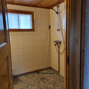 La salle de bains est pourvue d'une douche avec un tuyau. dans l'établissement Revontulen Tupa, à Kaamanen