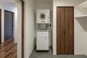 a laundry room with a washer and dryer and a microwave at Furano Peak in Furano