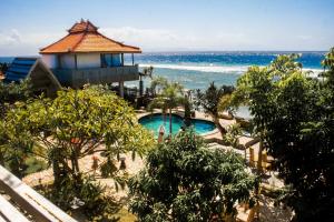 a view of a resort with a swimming pool and the ocean at Cemara Beachfront Nusa Penida in Batununggul