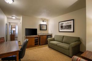 a living room with a couch and a table at Travelodge Suites by Wyndham Regina - Eastgate Bay in Regina