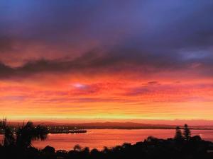 een zonsondergang boven een waterlichaam bij U Beauty - B & B in Whangarei