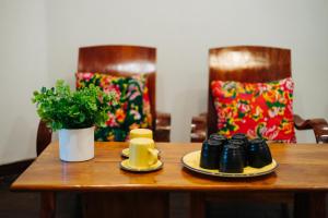 a wooden table with two plates and a plant on it at Legume House - 30m to centre in Hanoi