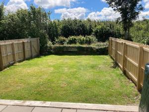 a backyard with a fence and a grass yard at Burren 1 Bed Detached Guesthouse in Galway