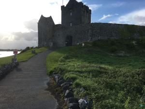 un viejo castillo en la cima de una colina de hierba en Burren 1 Bed Detached Guesthouse, en Galway