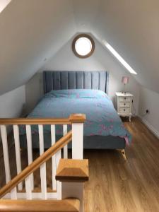 a bedroom with a bed with a blue comforter at Burren 1 Bed Detached Guesthouse in Galway