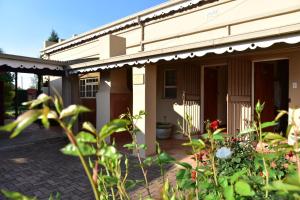 a house with an awning and plants in front of it at Villa Moria Romance in Dullstroom