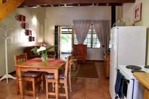a kitchen and dining room with a table and a refrigerator at Villa Moria Romance in Dullstroom