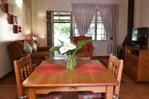 a dining room table with a vase of flowers on it at Villa Moria Romance in Dullstroom