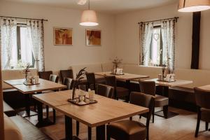 a restaurant with wooden tables and chairs and windows at Penzion Merica in Bor