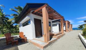 ein kleines Haus am Strand mit zwei Stühlen in der Unterkunft Goichi Resort in Dipaculao
