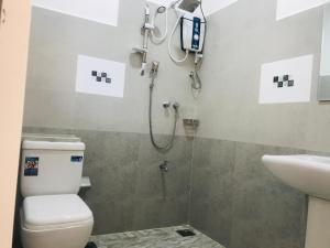 a bathroom with a shower and a toilet and a sink at Hotel Ganthera Kataragama in Kataragama