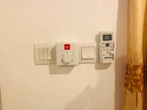 a room with a wall with a thermostat and aumption at Hotel Ganthera Kataragama in Kataragama