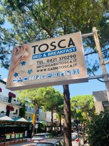 a sign for a seafood and breakfast restaurant on a street at Hotel Garni Tosca in Lido di Jesolo