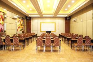 una sala de conferencias con mesas, sillas y una pizarra en Olympic Hotel, en Yakarta