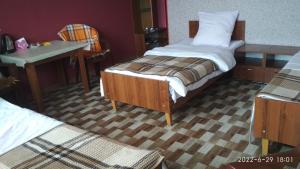 a bedroom with two beds and a table and a desk at Motel in Qusar