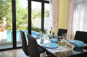 a dining room with a table and chairs and a pool at Baan Ping Tara Private Pool Villa in Ao Nang Beach