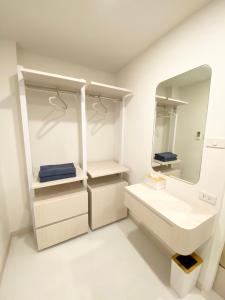 a white bathroom with a sink and a mirror at Mangkon Hostel in Bangkok