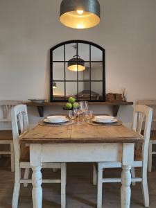 einen Holztisch mit Tellern und Weingläsern darauf in der Unterkunft Il Cortiletto - Suites & Apartments in Pistoia