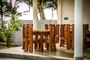 Infinity of Sri Lanka في Paiyagala South: طاولة وكراسي خشبية في مطعم