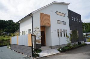 a white house with a black and white facade at SORAYADO 宙宿 in Tsuru 