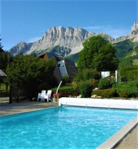 a large swimming pool with a mountain in the background at SCI jsm in Gresse-en-Vercors