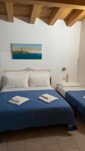 a bedroom with two beds with towels on them at Hotel Garni Tosca in Lido di Jesolo