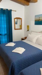 una camera da letto con un letto blu e asciugamani di Hotel Garni Tosca a Lido di Jesolo