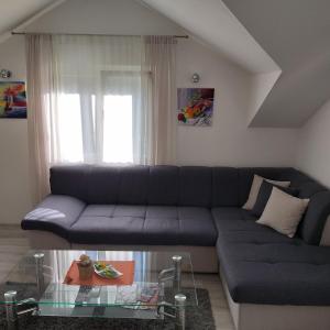 ein Wohnzimmer mit einem Sofa und einem Glastisch in der Unterkunft M&A in Trebinje