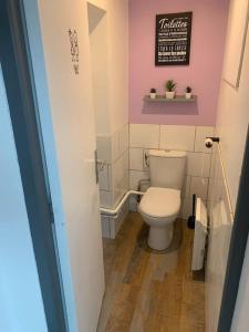 een badkamer met een toilet en een bord aan de muur bij la parisienne ( 4 km de rouen ) in Le Mesnil-Esnard