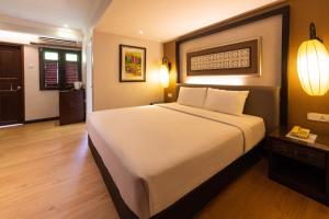 a bedroom with a large white bed in a room at Hotel Puri Melaka in Malacca