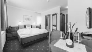 Hotel24Steps في ايشجل: غرفة في الفندق بها سرير وكأسين للنبيذ