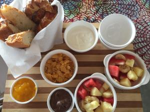 a table with four bowls of food with fruit and nuts at BONDENI BEACH HOUSE in Jambiani
