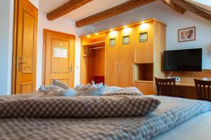 een slaapkamer met een bed en een flatscreen-tv bij Landhotel & Gasthof Baiernrain in Baiernrain