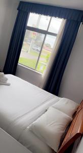 a bed in a room with a window at Lake Munmorah Motel in Lake Munmorah