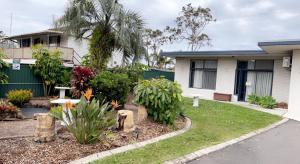 a house with a garden in front of it at Lake Munmorah Motel in Lake Munmorah