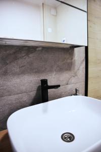 bagno con lavandino bianco e specchio di Apartament Feeling Home în cartier WestResidence a Oradea