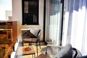 uma sala de estar com uma cadeira e uma mesa em Apartament Feeling Home în cartier WestResidence em Oradea