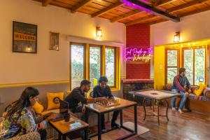 a group of people sitting at tables in a room at The Hosteller Ramgarh, Nainital in Rāmgarh