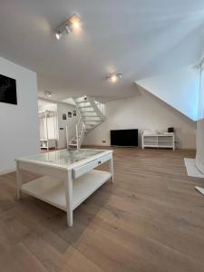 a living room with a white table and a staircase at Ruhrgebiet-Apartments in Duisburg Stadtmitte in Duisburg