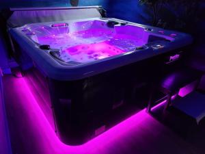 a hot tub with pink lights in a room at Effet Mer, 4 etoiles, gîte de 80m2 in Dorlisheim