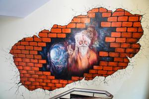 a brick wall with a painting of a guru on it at Madpackers Rishikesh Ganga View in Rishīkesh