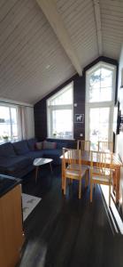 sala de estar con sofá, mesa y sillas en Lakeside log cabin Främby Udde Falun, en Falun