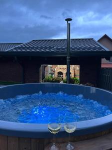 Una gran bañera azul con dos copas de vino. en Brick House, en Borşa