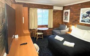 GuyraShiralee Motel Guyra的一间带床和客厅的酒店房间
