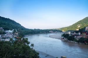 uitzicht op een rivier met gebouwen en een stad bij Madpackers Rishikesh Ganga View in Rishīkesh