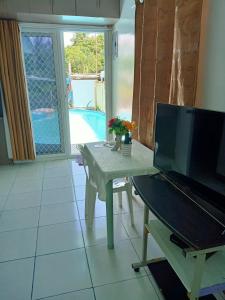 sala de estar con mesa y TV en Okoy Guest House, en Bantayan Island