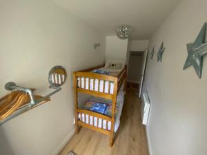 a small room with a bed and a mirror at Newton Croft Tenby overlooking North Beach in Tenby